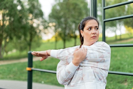 A woman stretching outdoors before a run.
